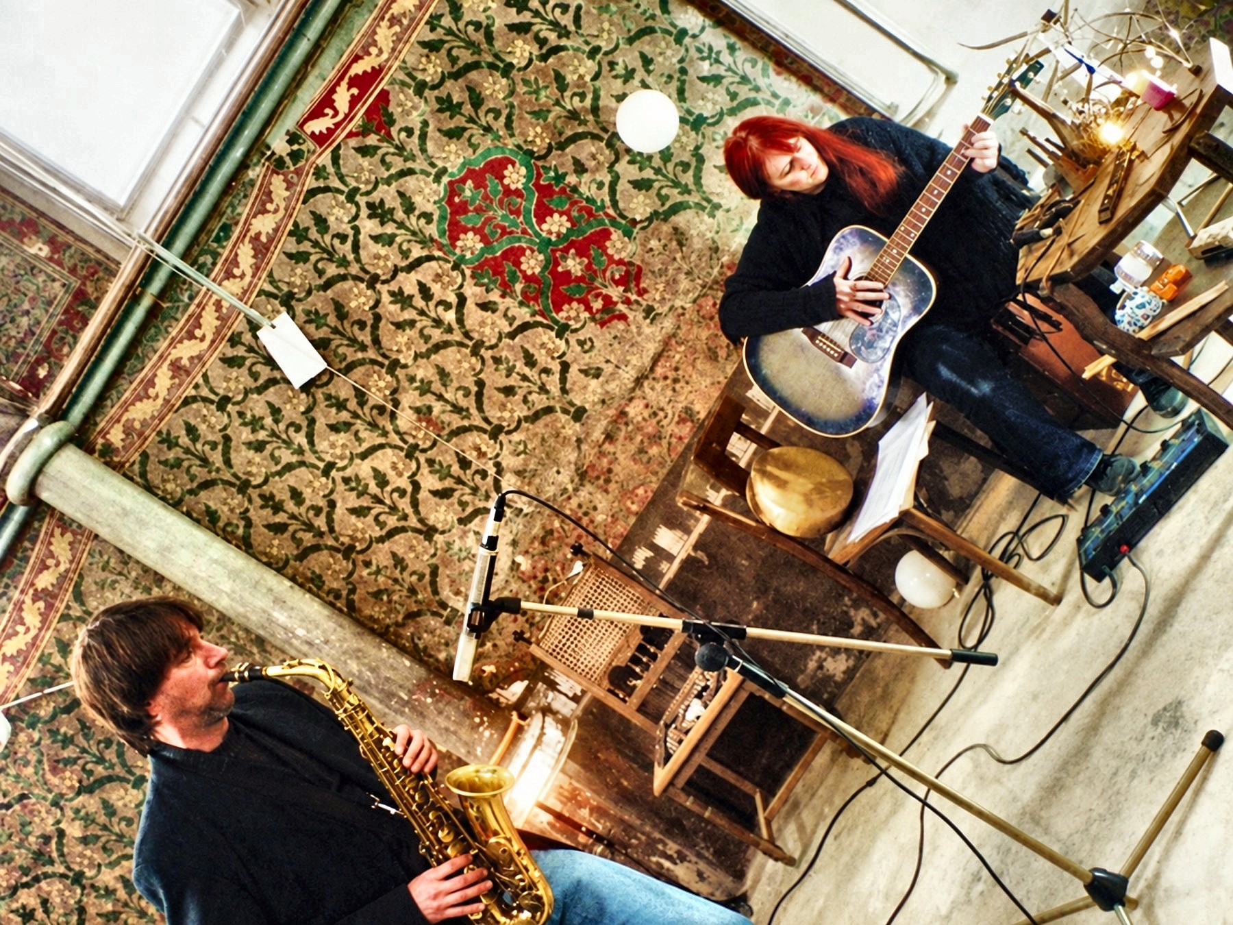 Dan Magay playing saxophone beside a guitarist, seen from above