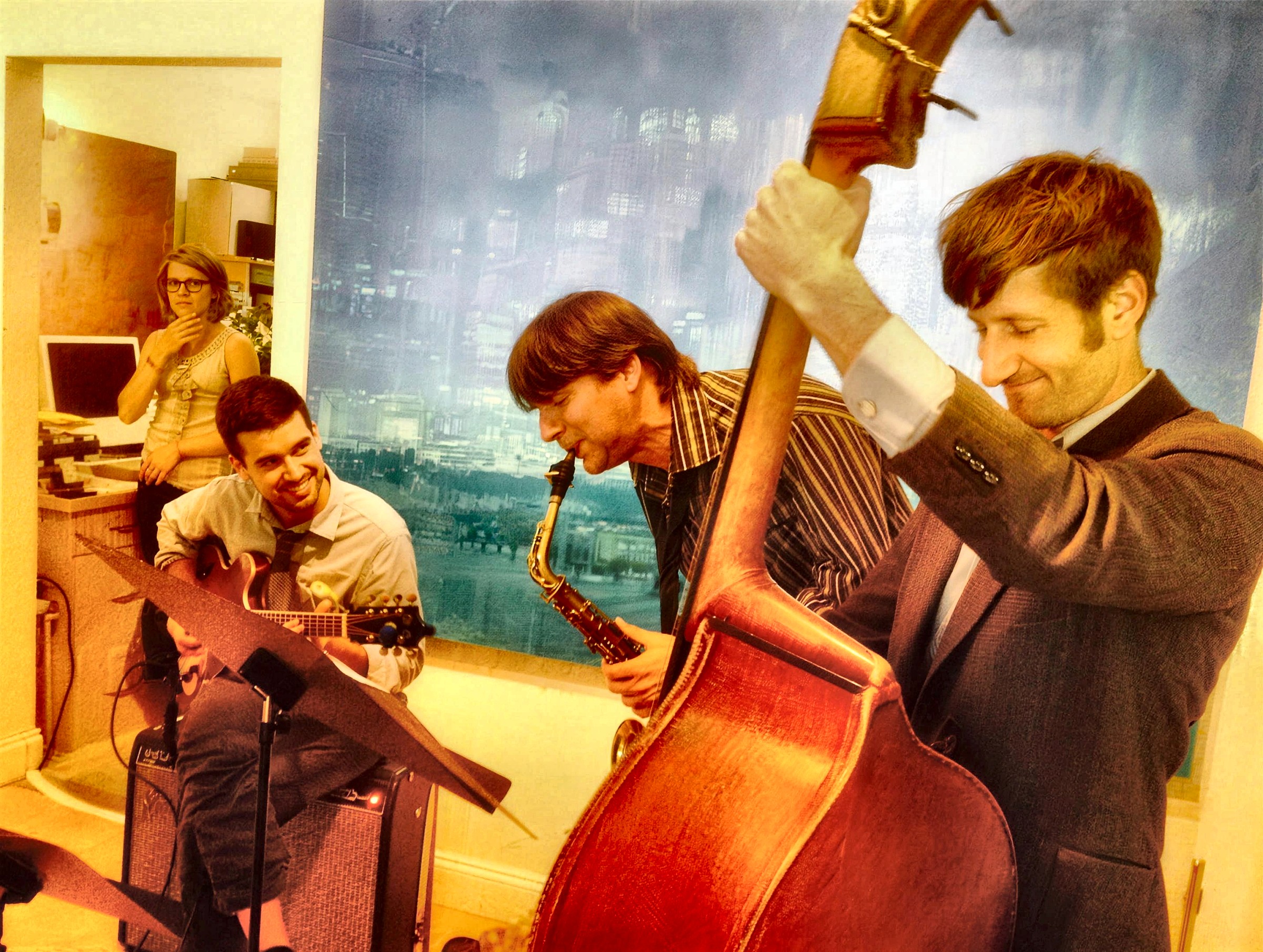 The trio playing before a blue painting