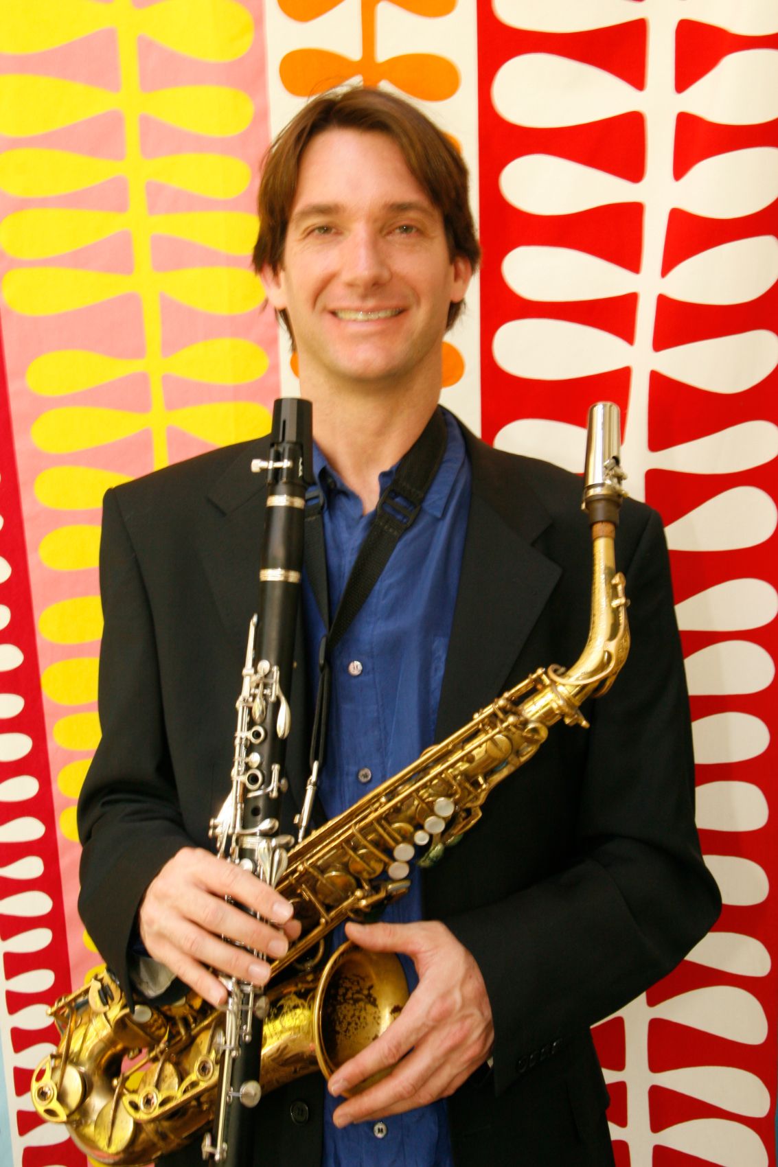 Dan Magay smiling with his clarinet and flute